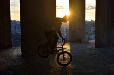 Adam yapmak bir hüner günbatımı gökyüzü karşı bir bmx bisiklet sürme. Aşırı spor