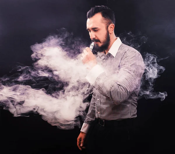 Férfi szakáll vaping és mentesít egy felhő a gőz. — Stock Fotó