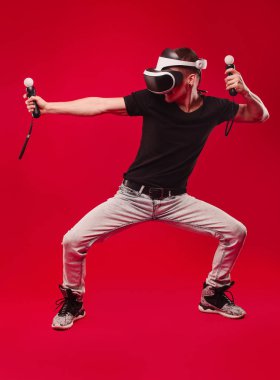 Kırmızı bir arka plan üzerinde izole jest gösterilen sanal gerçeklik gözlüklü adam