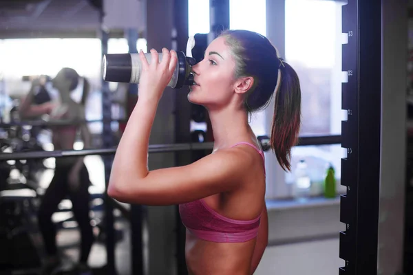 Молодая мускулистая женщина, пьющая спортивное питание . — стоковое фото