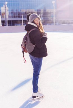 Genç kadın moduna açık paten pistinde kışın kaymaktadır.