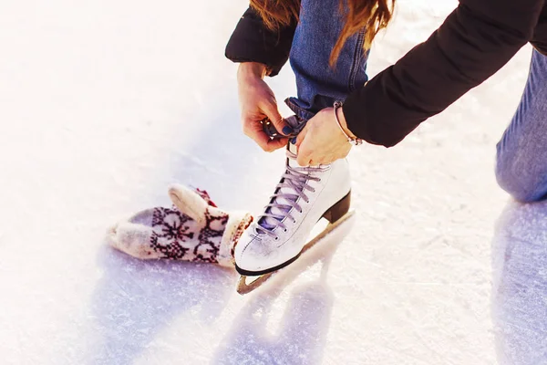 Figure skates in snow close-up, woman tie shoelaces
