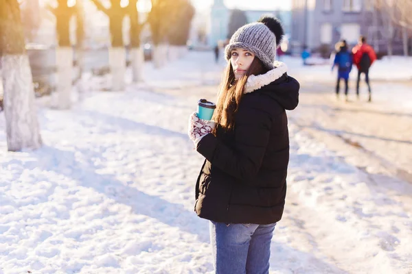 Femme gaie dans la rue buvant le café du matin au soleil. Vue arrière. Concept d'hiver — Photo