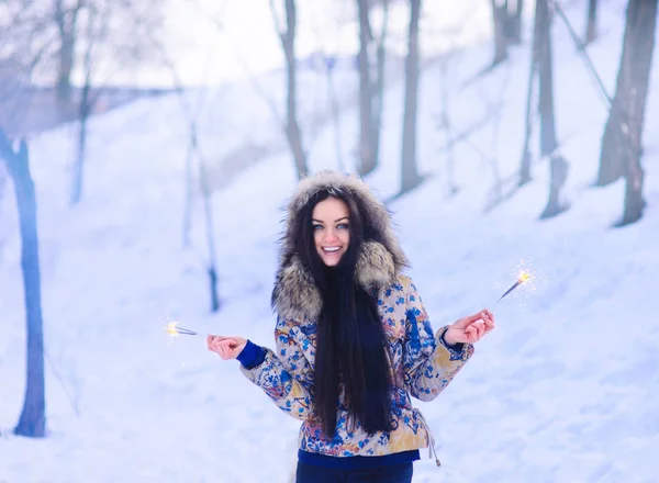 冬の森で花火を持って陽気な女の子 — ストック写真