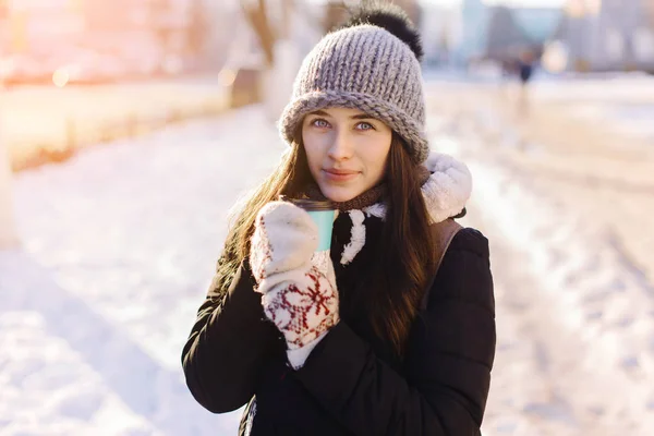 冬のファッション冬背景に使い捨てカップを保持している陽気なゴージャスなブルネット — ストック写真