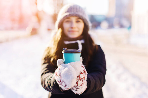 Paper cup with coffee in hand at the girl