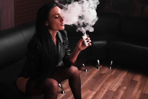 Молодая женщина курит электронную сигарету — стоковое фото