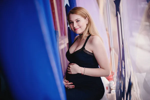 Беременная женщина сидеть у окна — стоковое фото
