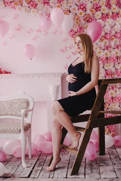 Беременная женщина сидит на лестнице — стоковое фото