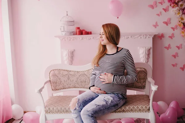 Feliz embarazo sentado en el sofá en casa en el dormitorio —  Fotos de Stock