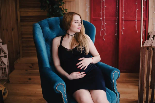 Беременная женщина сидит на кресле — стоковое фото