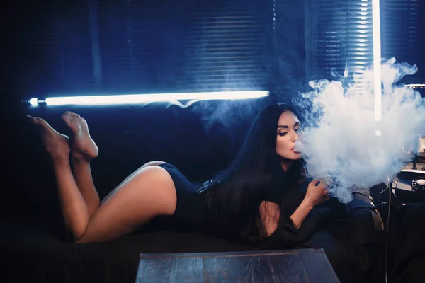 Fumar vape mod de uma forma sexy, mulher no sofá, conceito vape — Fotografia de Stock