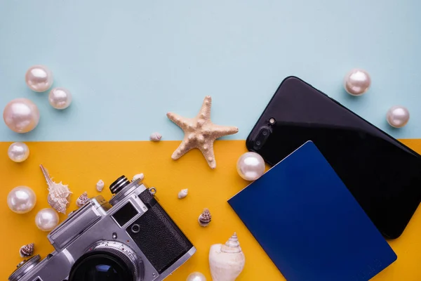 Accesorios de viaje sobre fondo azul y amarillo. Artículos de vacaciones esenciales. Concepto de viaje, vista superior . — Foto de Stock