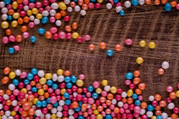 Coloridos caramelos de Pascua sobre un fondo rústico de madera — Foto de Stock