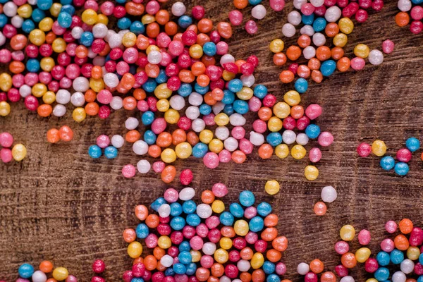 Textura de fondo colorido con azúcar caramelo espolvorea punto sobre fondo de madera — Foto de Stock