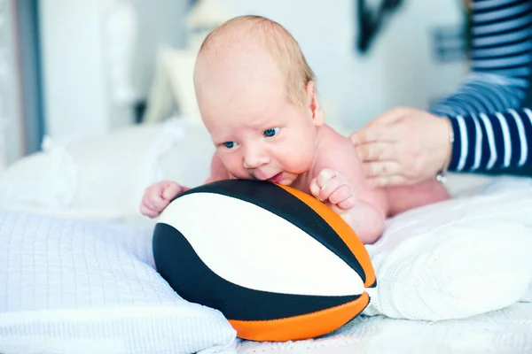 Menino pequeno doce com uma bola de fuutball americana — Fotografia de Stock
