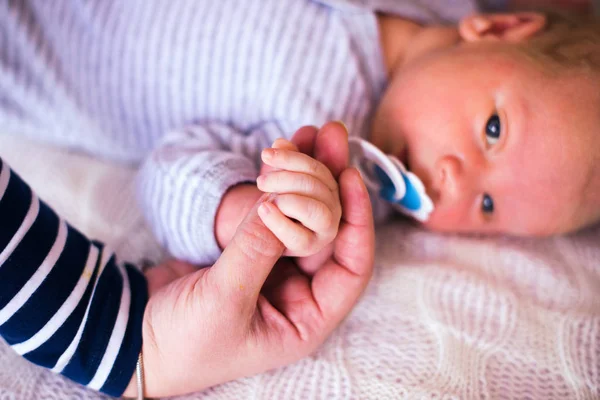 Newborn baby holding mother's hand, image with shallow depth of field — Stock Photo, Image