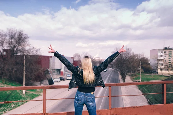 Mujer joven extendiendo las manos abiertas con la ciudad en el fondo. Concepto de libertad. Amor y emociones, felicidad de la mujer . — Foto de Stock