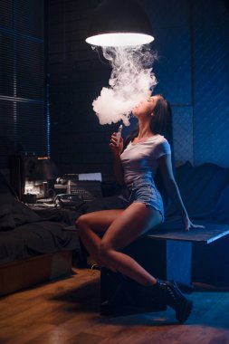 Yakın çekim seksi genç hipster yasaktır (vaping) kız portresi. Buharı kavramı. Vaping e-sigara.