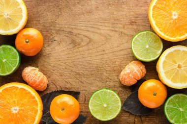 Turunçgil meyvesi. Portakallar, limonlar ve limonlar. Kopya alanı olan tahta masa arkaplanı