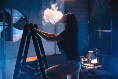 Vaping seksi bir kadındır. Stüdyo çekim.