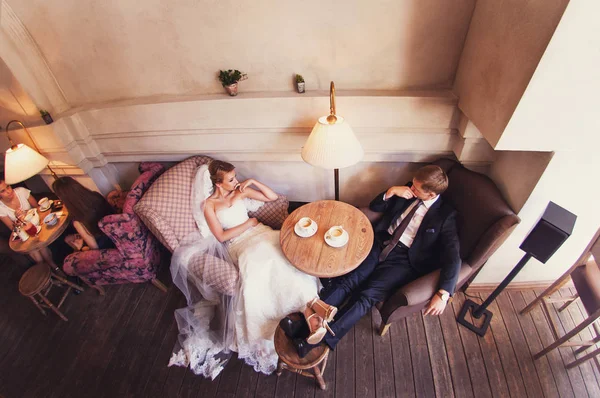 Bruid en bruidegom zijn koffie drinken op een indoor café bovenaanzicht — Stockfoto