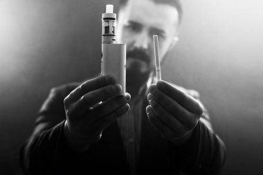 holding bir mod ve sigara vaping adam. Buhar bulutu.
