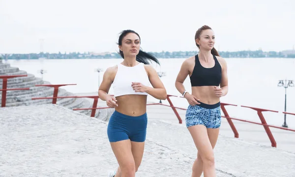嬉戏的两个漂亮女人在早上-户外跑步训练在早上的女性朋友 — 图库照片
