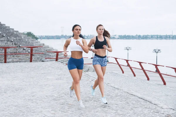 风景秀丽的追求他们的活动在户外在城市的两个女性慢跑 — 图库照片