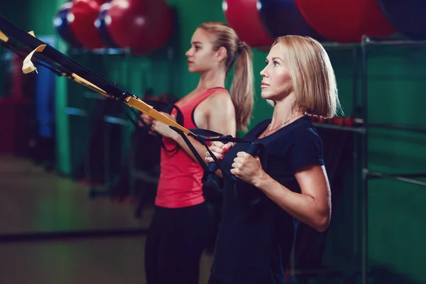 Schöne junge Sportler trainieren mit trax im Fitnessstudio — Stockfoto