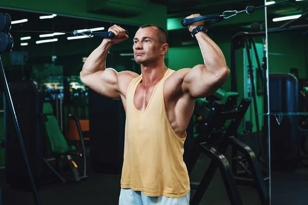 Handsome power athletic man on diet training pumping up back muscles pull up. Strong bodybuilder with six pack, perfect abs, back, shoulders, biceps, triceps and chest