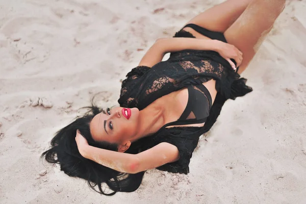 Модель Мбаппе в черном платье отдыхает на пляже — стоковое фото