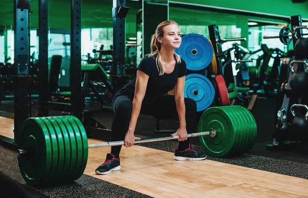 Kadın gerçekleştirme deadlift egzersiz ile kilo bar yapmak — Stok fotoğraf