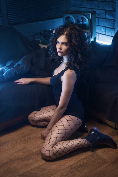 Güzel kıvırcık genç kadın esmer modelinde katta oturan tayt