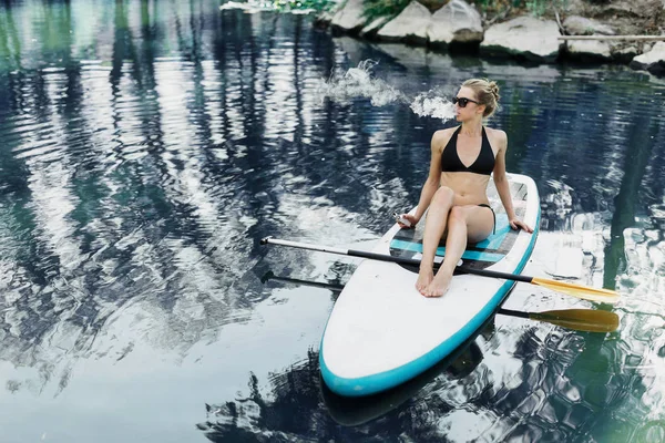Woman vaping on sup board. paddle board on the lake — Stock Photo, Image