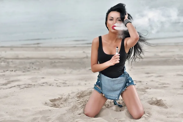 Sahilde duman ile gözlük vaping \beautiful esmer. Buharı kavramı.