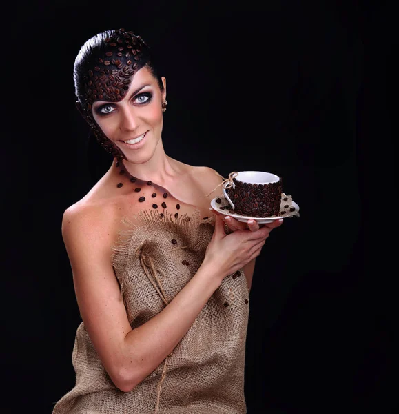 Güzellik genç kadın yüzü ile Kupası elinde kahve çekirdekleri içinde boğulma portresi — Stok fotoğraf