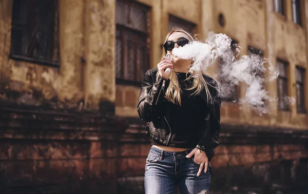 Vapeado. Joven hermosa mujer fumando (vapeo) cigarrillo electrónico con humo al aire libre. Concepto de vapor . — Foto de Stock