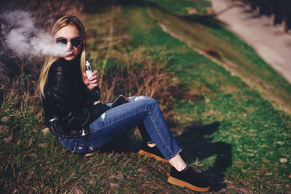 Vapor. Mulher bonita jovem fumando (vaping) e-cigarro com fumaça ao ar livre. Conceito de vapor . — Fotografia de Stock