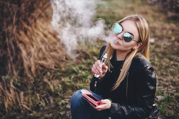 Vaping. Genç güzel kadın (vaping) e-sigara duman açık havada ile. Buharı kavramı. — Stok fotoğraf