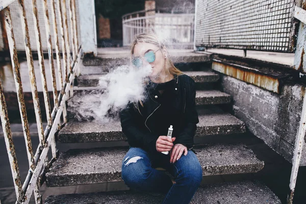Vaping. Genç güzel kadın (vaping) e-sigara duman açık havada ile. Buharı kavramı.