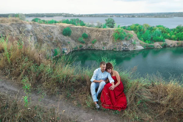 Portré, fiatal, gyönyörű pár szerelmes ült a víz közelében — Stock Fotó