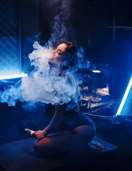 Genç güzel kadın (vaping) e-sigara dumanı ile