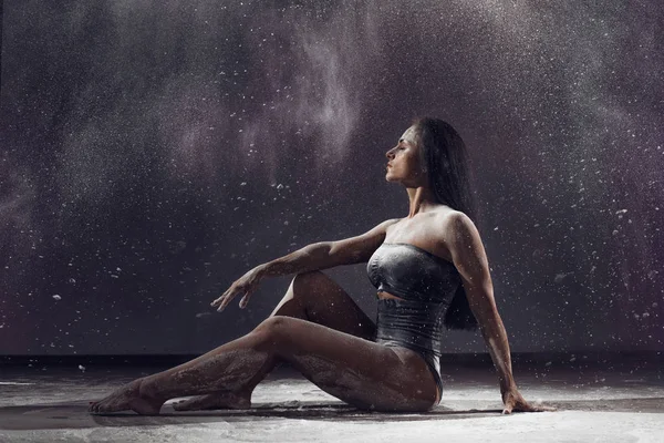 Bailarina actuando sobre fondo negro con estallido de polvo para mostrar potencia y movimiento. Bailarina realizando sobre fondo negro con polvo . — Foto de Stock