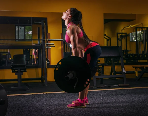 Muscular joven fitness mujer haciendo ejercicio de levantamiento de pesas pesado en el gimnasio — Foto de Stock