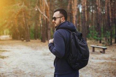 Fiyatı - adam ormanda hiking. Ormandaki bardaklarda erkek uzun yürüyüşe çıkan kimse. Doğada açık havada beyaz erkek modeli.