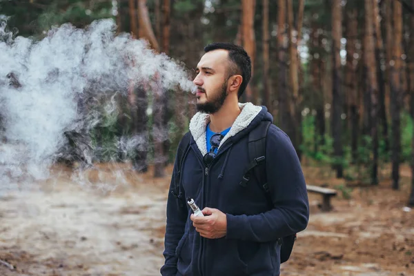Hombre con barba fumar sigarette electrónica al aire libre — Foto de Stock