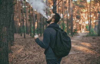 Vaping. e-sigara açık havada olan sakallı adam.