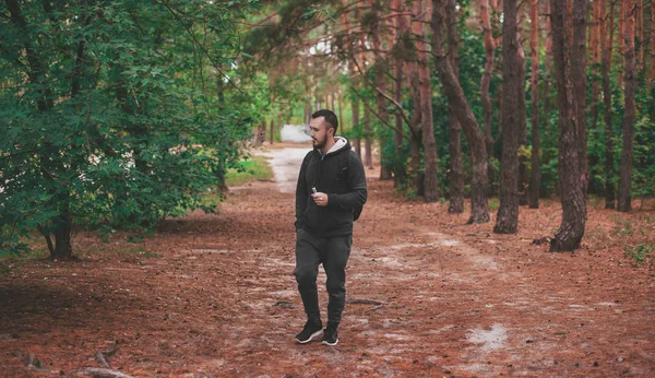adam vaping sakallı ve ormanıyla sırt çantası yürüme