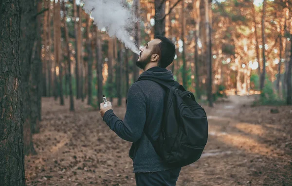 Vapeado. barbudo hombre con e-cigarrillo al aire libre . — Foto de Stock